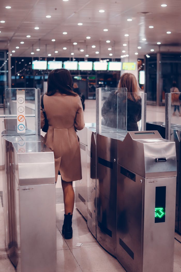 People passing through metro turnstile in modern station, showcasing travel infrastructure.