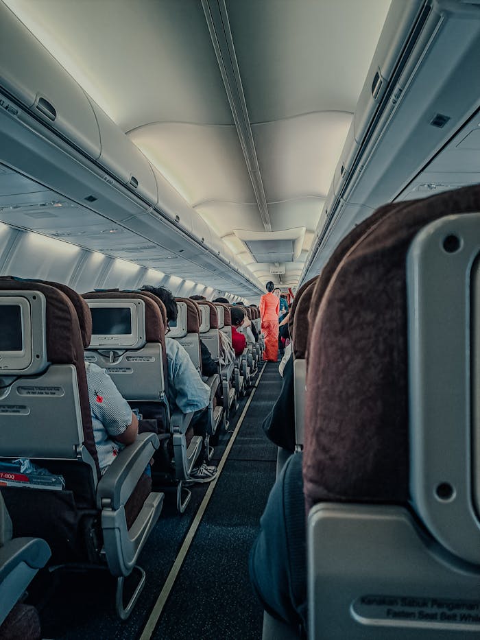 Interior of a commercial airplane with passengers seated, showcasing the cabin environment during flight.
