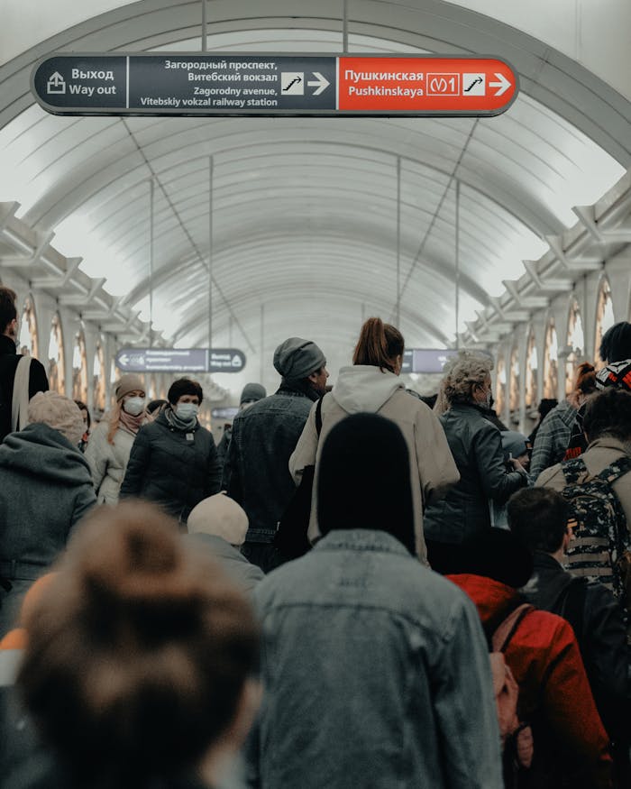 A crowded scene at Pushkinskaya station in Saint Petersburg, showcasing commuters wearing masks.